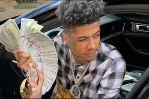 An image of Blueface alias "Johnathan Jamall Porter" holding a bunch of dollar notes