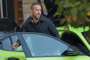 An image of Ryan Reynolds getting into his green car