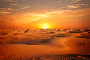 Endless sands stretch beneath the blazing sun, illustrating the stark beauty of a desert landscape.