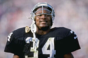 An image of Bo Jackson playing in the NFL and what is his Net Worth