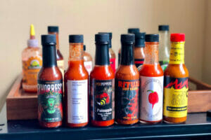 Scorching hot sauce bottles lined up on a table, representing the world's spiciest condiments.