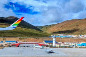 An aerial view of Qamdo Bamda Airport, nestled in the high-altitude region of Tibet. The airport's impressive runway, the longest in the world, stretches across the landscape.